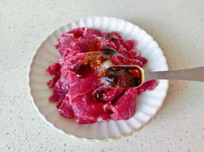加入甜面酱一勺，淀粉一勺抓拌均匀后淋上少许的食用油锁住牛肉的水份，再腌制十分钟。