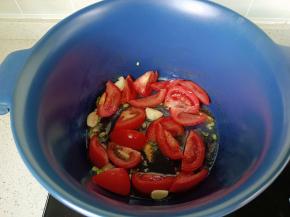 锅里加入葱花，蒜炒香后加入番茄翻炒出汁。