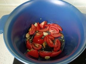 锅里加入葱花，蒜炒香后加入番茄翻炒出汁。