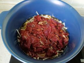 再依次码上牛肉片，加半碗水盖上盖子开大火煮。