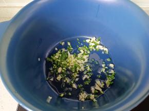 锅里倒适量的食用油，放上葱花，蒜末炒香。