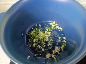 锅里倒适量的食用油，放上葱花，蒜末炒香。