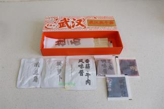 打开热干面的盒子，里面有90克挂面、香菇牛肉风味酱、酸豆角、腌萝卜、芝麻调味酱、辣椒油、调味汁。这个配菜里增加了牛肉酱，味道醇香，更好吃。