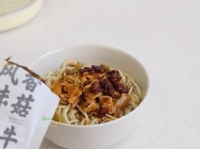 把香菇牛肉酱、调味汁、辣椒油、腌萝卜、酸豆角，所有配菜，倒入面条的碗里，搅拌均匀