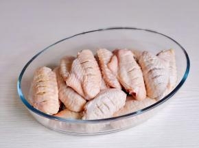 鸡翅洗净后正反面各划几刀，用厨房用纸擦干放入器具中。