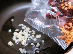 锅里加入1勺油，下入蒜末爆香后倒入干辣椒包翻炒出香味