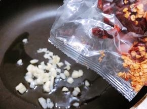 锅里加入1勺油，下入蒜末爆香后倒入干辣椒包翻炒出香味