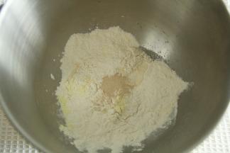 除了盐、黄油，其余材料放入打面桶。酵母不与糖接触。牛奶预留10克看成团情况加。