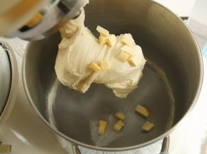 装好冷冻好的冰袋，开1档混合成团，转4-5档6-8分钟打至粗膜状态，面团略光滑，加盐和黄油。