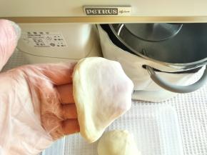 2档打到黄油与面团混合，转4-5档搅打至出膜。打好的面团取出折叠收圆，取一小块检查，扯开较为结实的半透明膜即可。