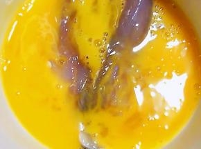 煨制入味的黄花鱼放入打散的蛋液中蘸匀