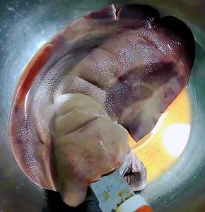 新鲜的猪肝在清水中浸泡半小时去除血水后洗净用小刀在猪肝较厚的一端中间割开轻轻向深部划切记不要割断