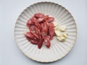 腊肠切斜片，大蒜切片。
