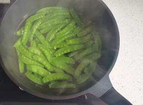 锅中烧开水，加少量油和盐，放入荷兰豆焯水1分钟捞出过凉。