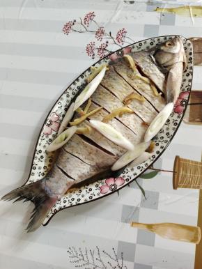 武昌鱼清洗干净，在鱼身上划几刀。放入适量的盐，料酒，姜丝，大葱涂抹均匀，腌制20分钟！