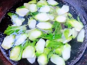 锅中烧开水放入儿菜焯水断生后立即放入冷水中过凉