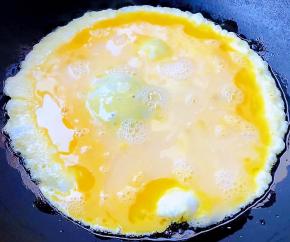 锅中倒入底油加热倒入打散的鸡蛋液