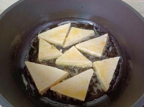 窝里放适量的食用油，油温五成热放豆腐煎。
