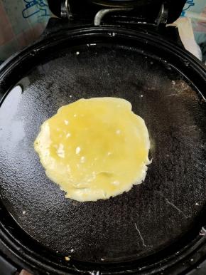 电饼铛提前预热，刷一层薄油！舀一勺蛋液倒进去，勺子底部慢慢的转动，摊成一个小圆饼的形状！
