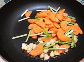 加入胡萝卜和韭菜白段翻炒1分钟