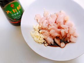 碗里放入鸡胸肉丁，蒜末，加入六月鲜特级酱油