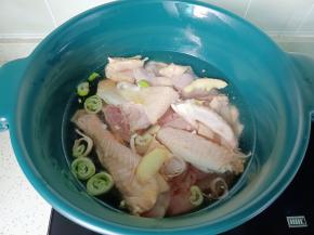 把三黄鸡放入锅里，加生姜，葱段，料酒焯水。