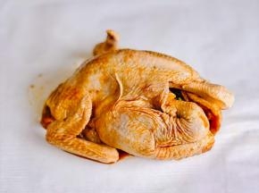 腌制好的鸡放在油纸上包起来。