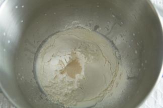 除了盐和黄油，其余材料放入打面桶。酵母不与糖接触。厨师机1档混合成团，转4-5档打至粗膜状态。