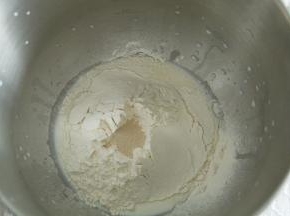 除了盐和黄油，其余材料放入打面桶。酵母不与糖接触。厨师机1档混合成团，转4-5档打至粗膜状态。