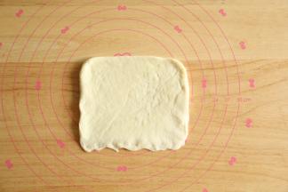 翻面后长边在上，整理后从上往下卷起，收口捏紧。