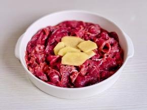 牛肉片放入盘中加姜片。