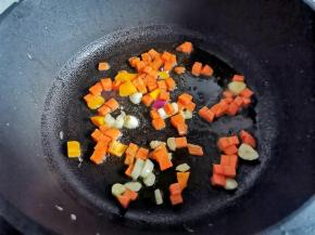 锅中热油，爆香大蒜，加胡萝卜炒熟。