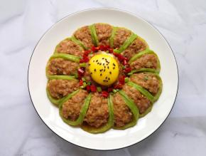 将调好的料汁用勺子浇在萝卜酿肉上面，蛋黄上面撒一点熟黑芝麻装饰，这道菜完成。