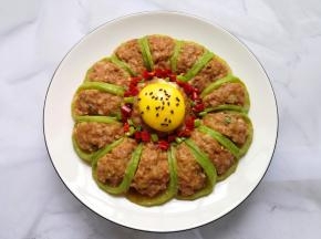 将调好的料汁用勺子浇在萝卜酿肉上面，蛋黄上面撒一点熟黑芝麻装饰，这道菜完成。