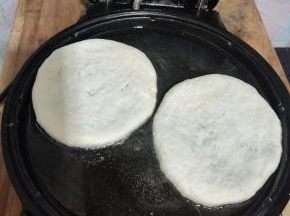 电饼铛提前预热，放入适量的油，把做好的饼胚放进去，表面再刷一层油，盖上盖子！