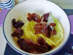 锅里铺一层白菜，放上木耳。