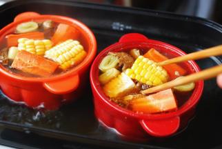 半小时后，放入玉米和胡萝卜，继续炖煮。