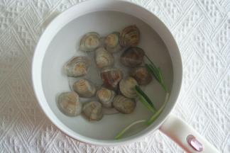 不粘锅中加小半锅水煮开，放入蛤蜊，葱段、1勺料酒焯水，蛤蜊开口后就捞出。
