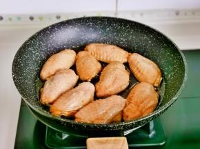 锅中倒油，油温6成热依次摆入鸡翅，全程小火慢煎。