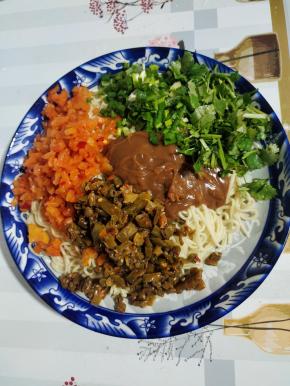 放入适量的调好的芝麻酱，酸豆角，萝卜干小咸菜，香菜，葱花！根据自己的喜好可以加入适量的香醋和辣椒油！