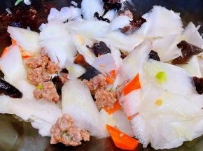 放入白菜梗炒出水份再放入胡萝卜、木耳、猪肉丸