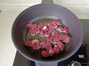 锅里倒入适量的食用油，油温五成热，放入切好的牛肉块。