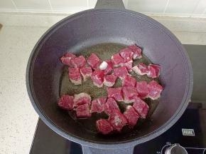 锅里倒入适量的食用油，油温五成热，放入切好的牛肉块。