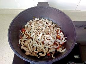 放入焯水后的蘑菇翻炒至蘑菇水分蒸发。