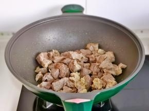 起油锅，倒入牛肉块煸炒。