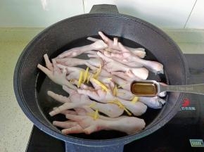 鸡爪冷水下锅，加入生姜丝，料酒开始焯水。