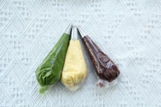 三色糊制作好，装入带裱花嘴的裱花袋中，用刮板沿着裱花袋尾部往前推，尾部拧紧。