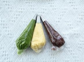 三色糊制作好，装入带裱花嘴的裱花袋中，用刮板沿着裱花袋尾部往前推，尾部拧紧。