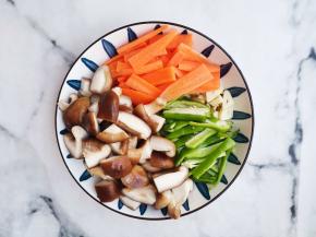 豆腐切小块、香菇切小块，胡萝卜切片，青椒切条，大蒜拍扁。