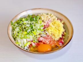 肉糜中葱姜蒜末，磕入鸡蛋搅拌均匀。